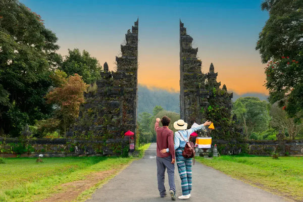 Er Bali trygt – trygg norsk turist på Bali med lokal guide og palmestrender i bakgrunnen